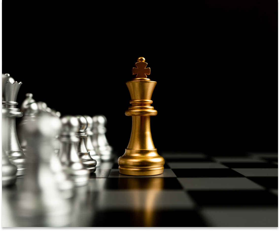 An elegant chess set featuring silver pieces and a golden queen figure, displayed on a black and gray board.